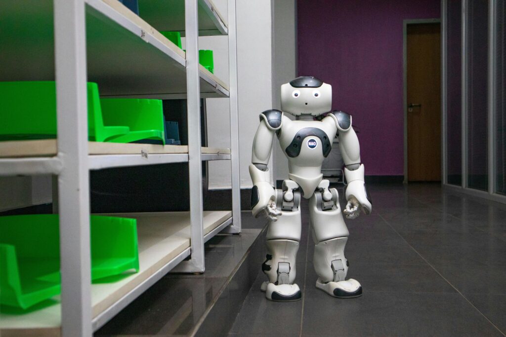 A humanoid robot standing in a modern corridor with shelves, representing futuristic technology.
